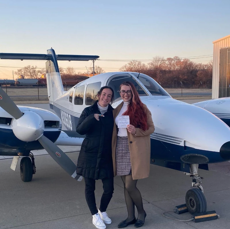 Student holding certificate besides CFI in front of a Multi-Engine aircraft